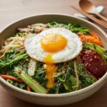 봄동 비빔밥 완성 사진, 푸짐한 봄동과 노른자가 흐르는 계란후라이가 올라간 모습