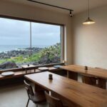 제주 조천 카페 치타델레의 아늑한 실내 인테리어와 창밖의 제주 풍경